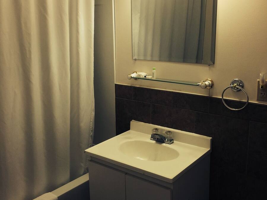 A bathroom with a white sink, a mirror, and a shower curtain.