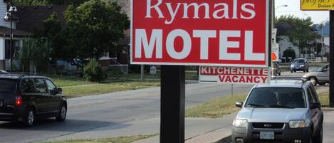 A motel sign with the name 'Rymals Motel' and a 'Kitchenette Vacancy' sign below it.
