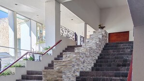 Una escalera con peldaños alternados de piedra y mármol negro, que conduce a un piso superior.