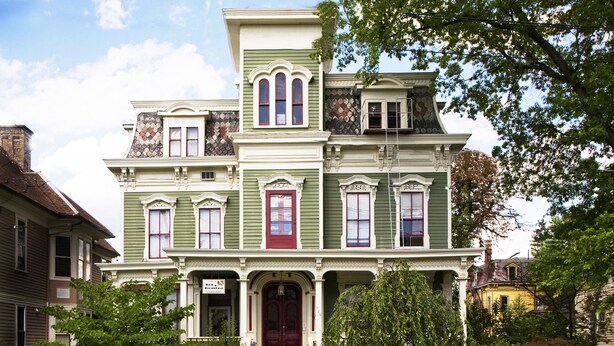 A Victorian-style house with a prominent front porch, multiple windows, and a red door. - Hudson City Bed & Breakfast (Hudson)