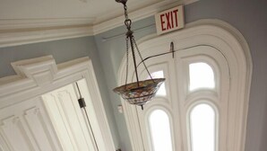 A grand staircase with a red carpet leading to a white door marked "EXIT". - Hudson City Bed & Breakfast (Hudson)