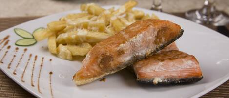 Un plato con salmón y papas fritas.