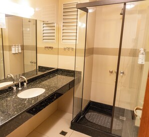 Un baño moderno con dos lavamanos, cabina de ducha de vidrio y espejo.