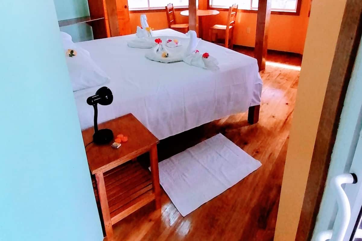 Una habitación con cama, escritorio, silla y ventana.