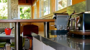 Una cocina moderna con techo de madera, pared de piedra y un amplio ventanal.