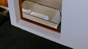Una habitación acogedora con una cama, un banco de madera y una pared de piedra.