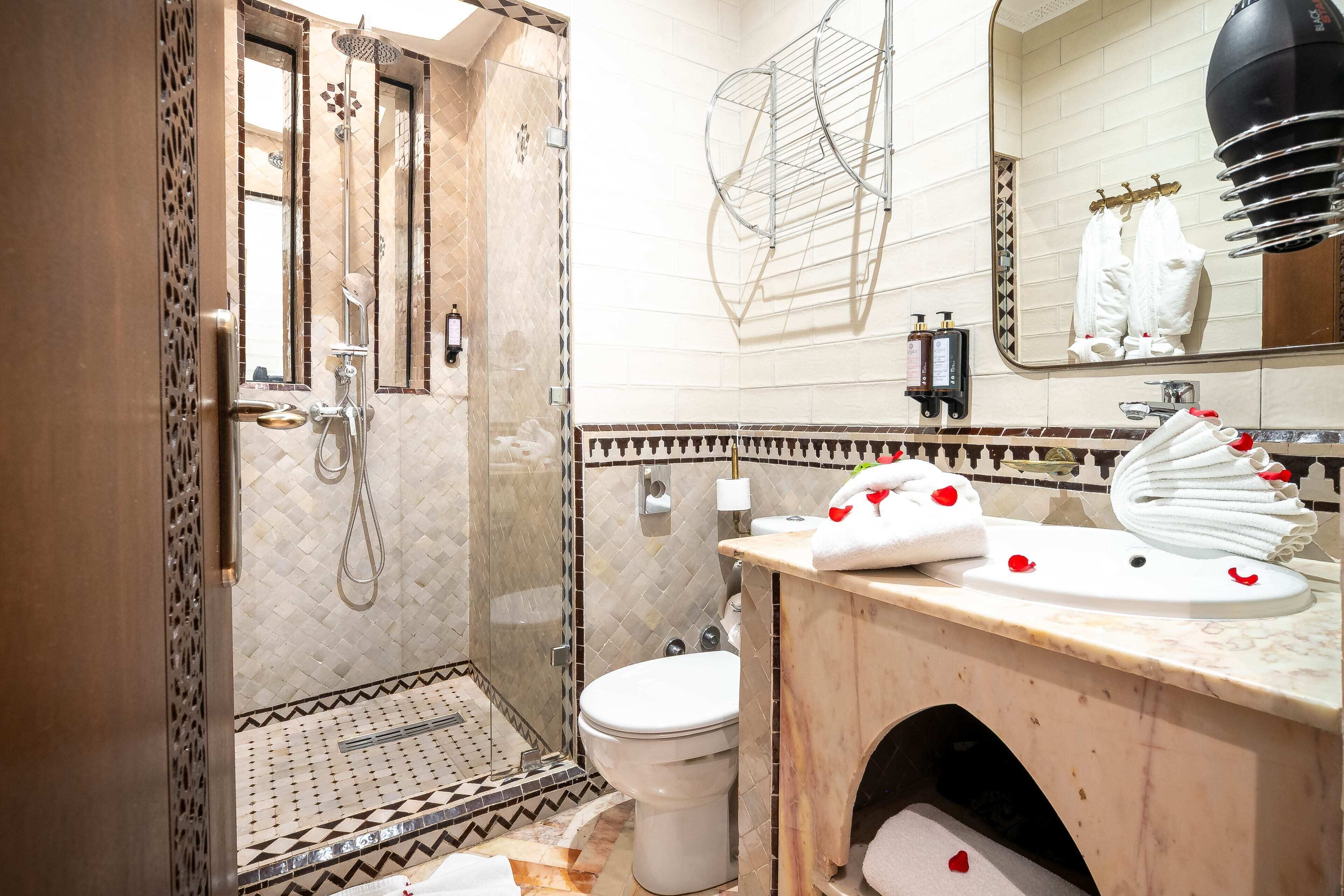 A bathroom with a shower, toilet, and sink.