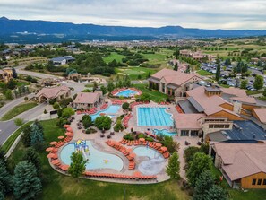 A resort with multiple swimming pools, a golf course, and a mountainous backdrop. - Flying Horse Resort & Club (Colorado Springs)