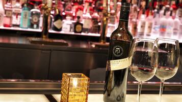 A bar setting with a bottle of wine, two glasses, and a decorative cube.