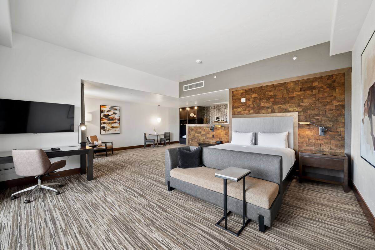 Een moderne hotelkamer met een groot bed, een bank, een bureau en een televisie.