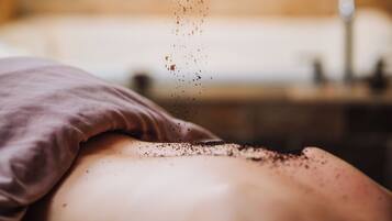 A close-up of a hand sprinkling a powdery substance onto a person's back.