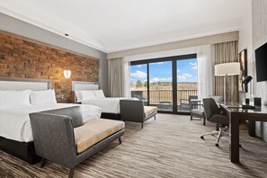 A hotel room with two beds, a desk, a chair, and a view of the outdoors. - Flying Horse Resort & Club (Colorado Springs)