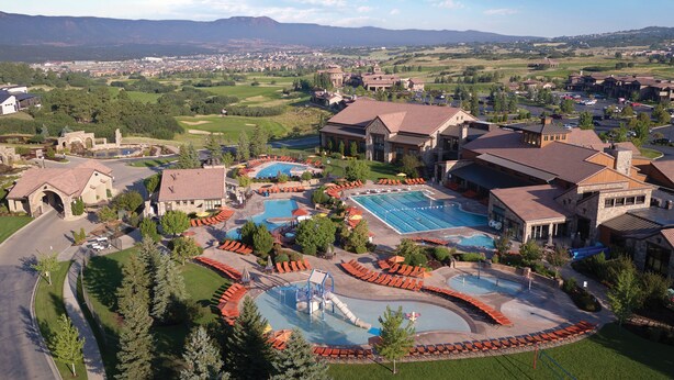 A resort with multiple swimming pools, a children's play area, and a view of the surrounding landscape. - Flying Horse Resort & Club (Colorado Springs)