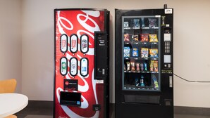 Due distributori automatici, uno con il logo Coca-Cola e l'altro con diversi snack.