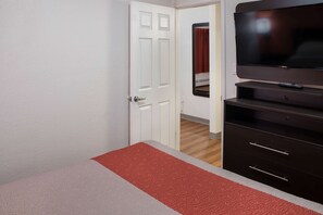 Ein Hotelzimmer mit Bett, Fernseher und Kleiderschrank.
