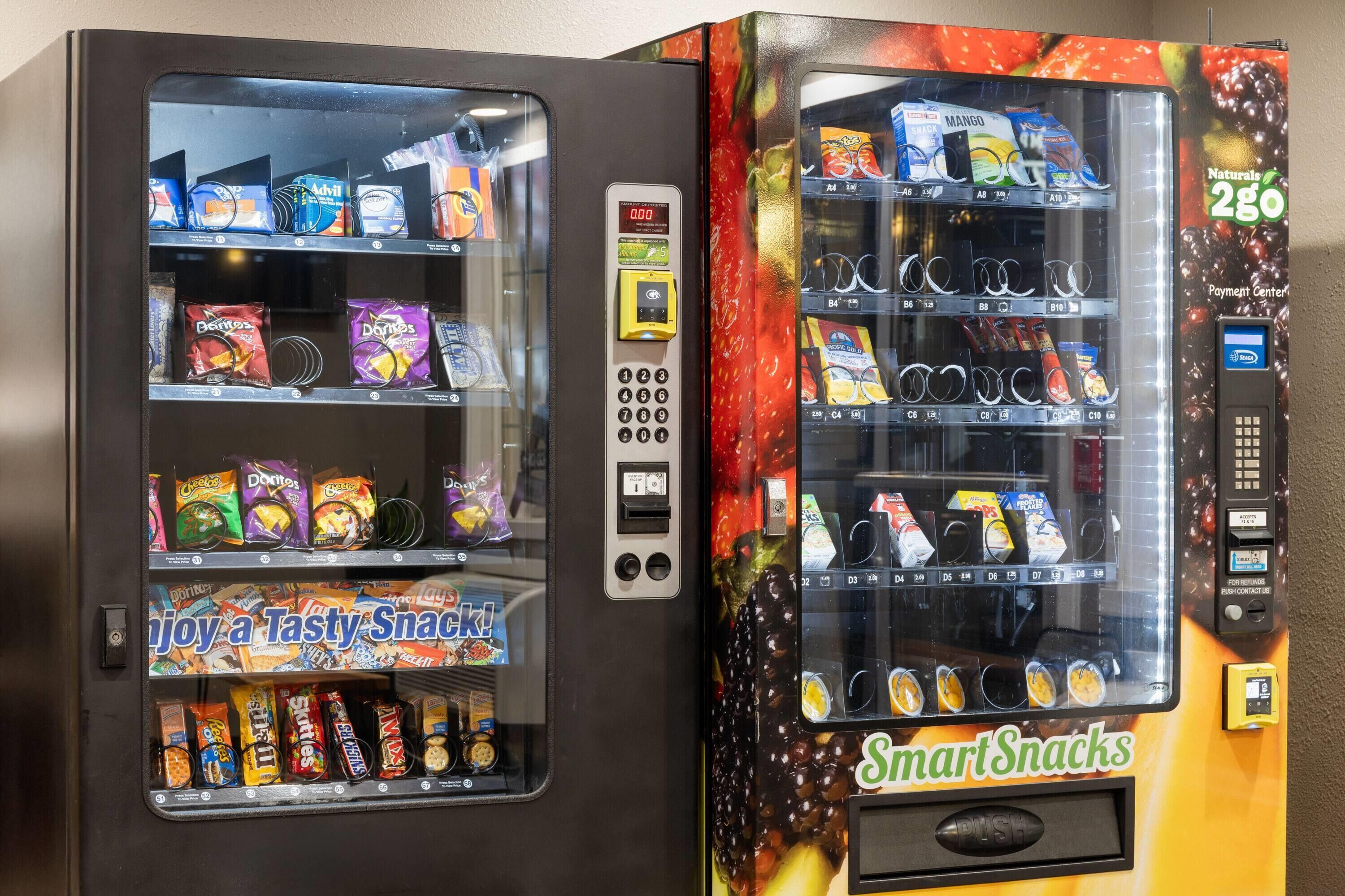 Two vending machines with snacks and drinks, one labeled "SmartSnacks" and the other with a digital display.