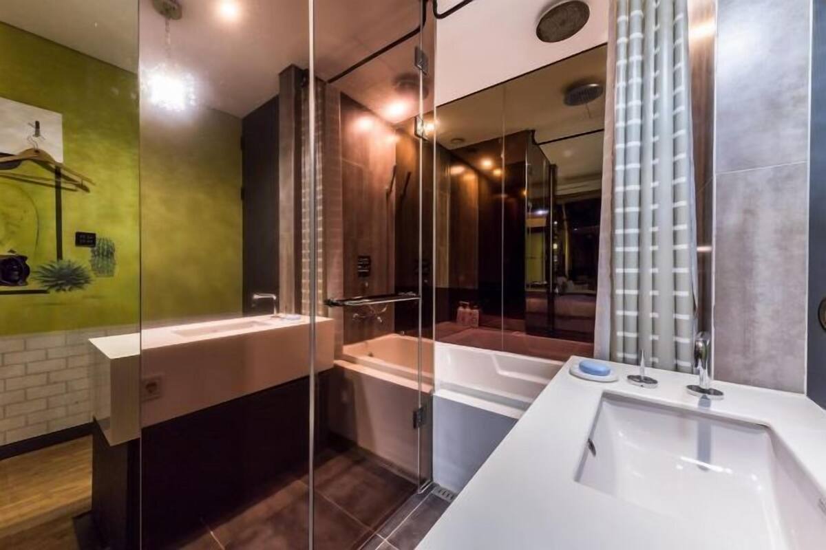 Badkamer | Een bad/douchecombinatie, een diep bad, gratis toiletartikelen