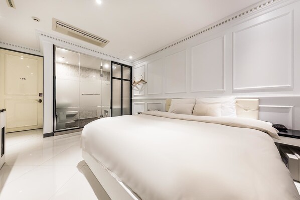 A modern bedroom with a large bed, a walk-in closet, and a glass shower enclosure. - Hotel Cullinan Jongno (Seoul)