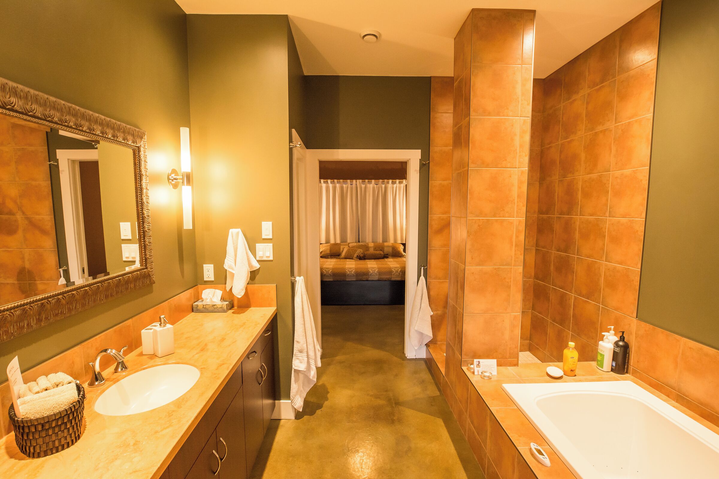 A bathroom with a large mirror, two sinks, a bathtub, and a shower area.