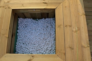 Una estructura de madera con interior verde lleno de guijarros blancos.