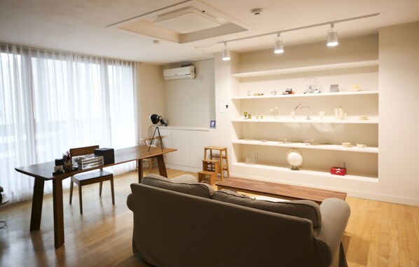 Una sala de estar con un sofá, una mesa de comedor y una estantería.