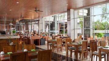 A spacious dining area with wooden furniture and large windows offering views of the outdoors.