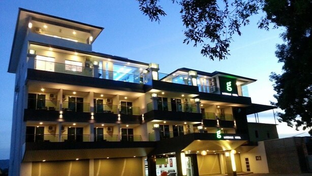 A multi-story hotel with balconies, a ground-level entrance, and a visible sign with a green 'E'. - G langkawi Motel (Langkawi)
