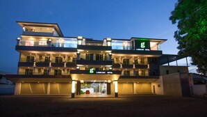 A multi-story hotel with a modern design, featuring balconies on each floor and a prominent entrance with signage. - G langkawi Motel (Langkawi)