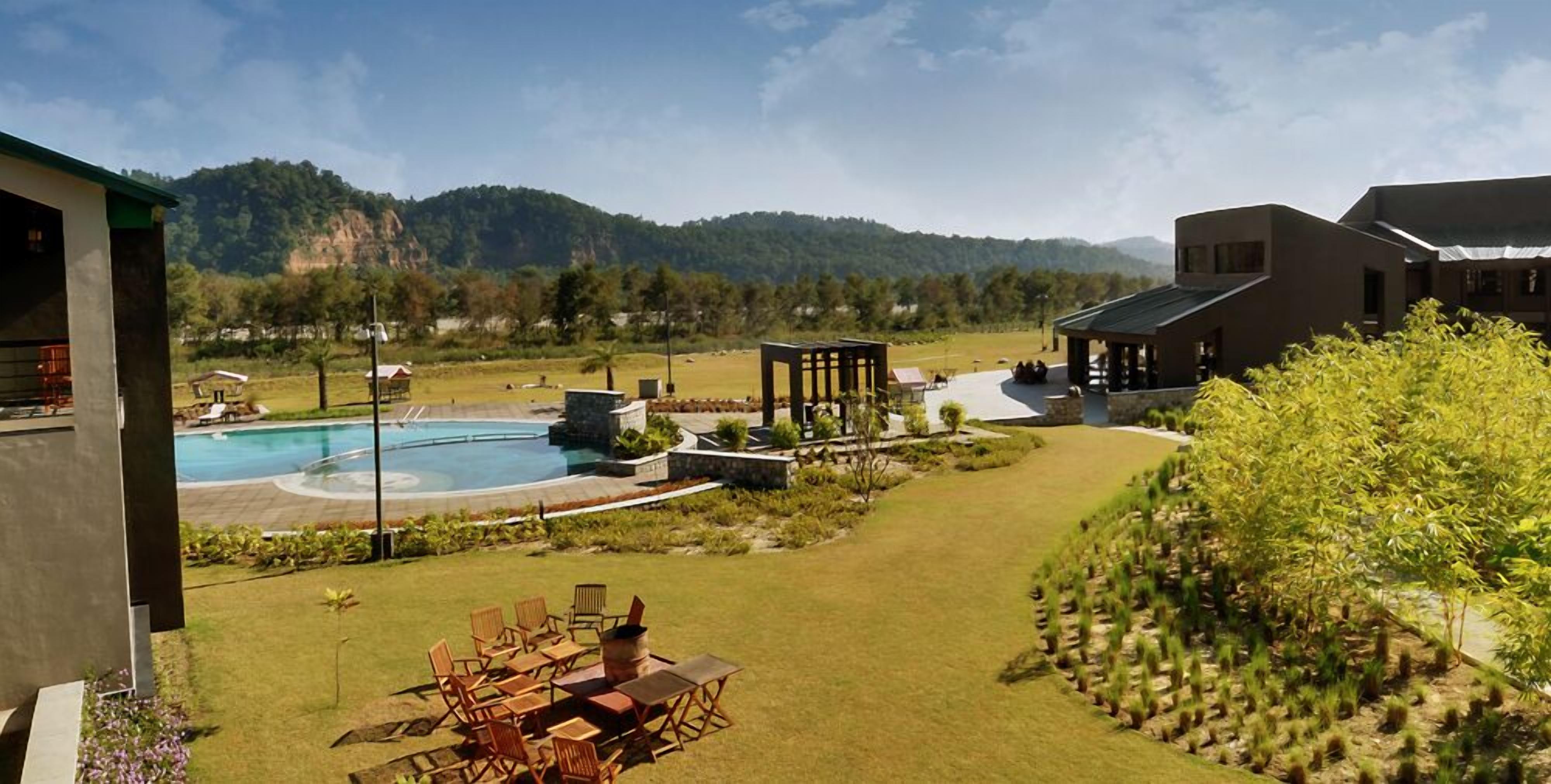 A pool area with a wooden deck, lounge chairs, and a gazebo.