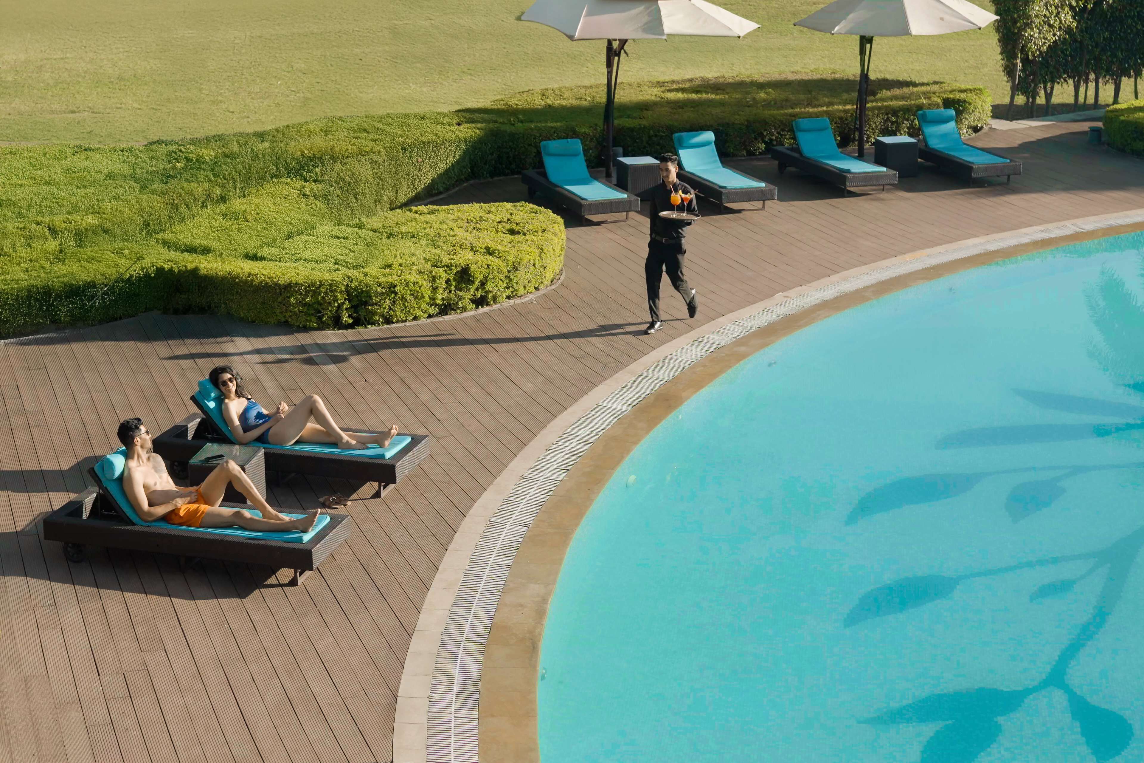 Een zwembadterras met ligbedden en parasols.