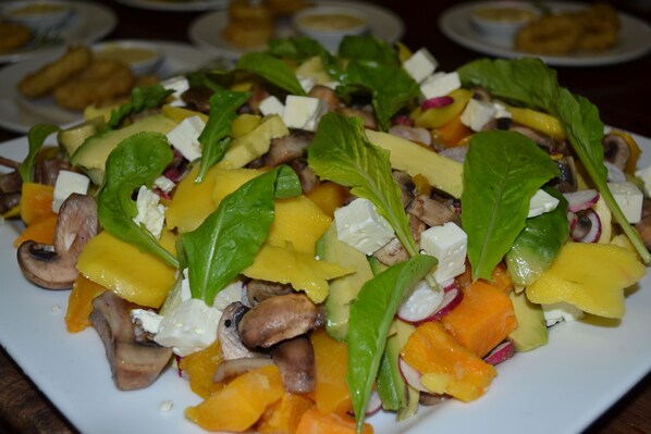 A plate of mixed salad with various vegetables and cheese.