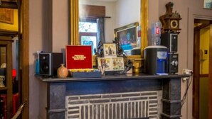 A room with a fireplace, a large mirror, and various decorative items on the mantel. - Hotel Ensor (Bruges)