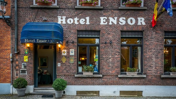 Hotel ENSOR with a brick facade, a blue awning, and multiple windows. - Hotel Ensor (Bruges)