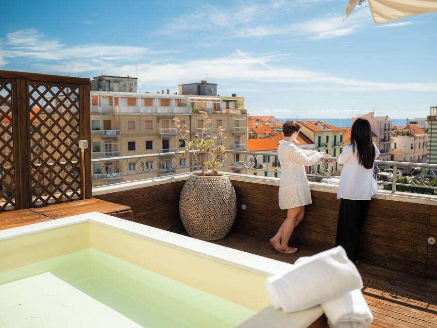 Una terraza en la azotea con piscina, un deck de madera y vistas de la ciudad.