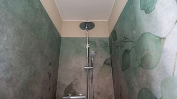 A shower with a handheld showerhead and a wall-mounted faucet.