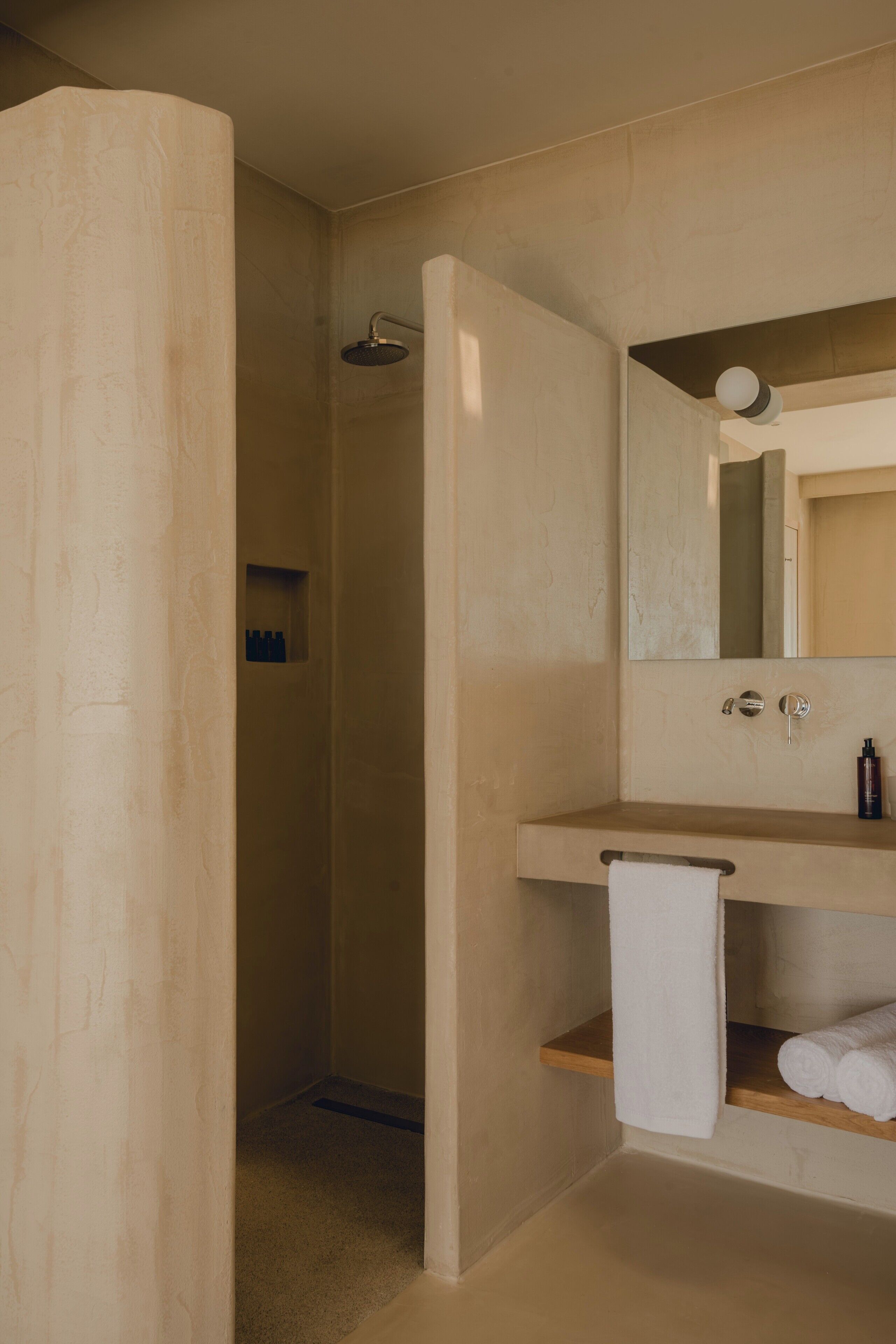 A modern bathroom with a shower, a sink with a mirror, and a towel rack.