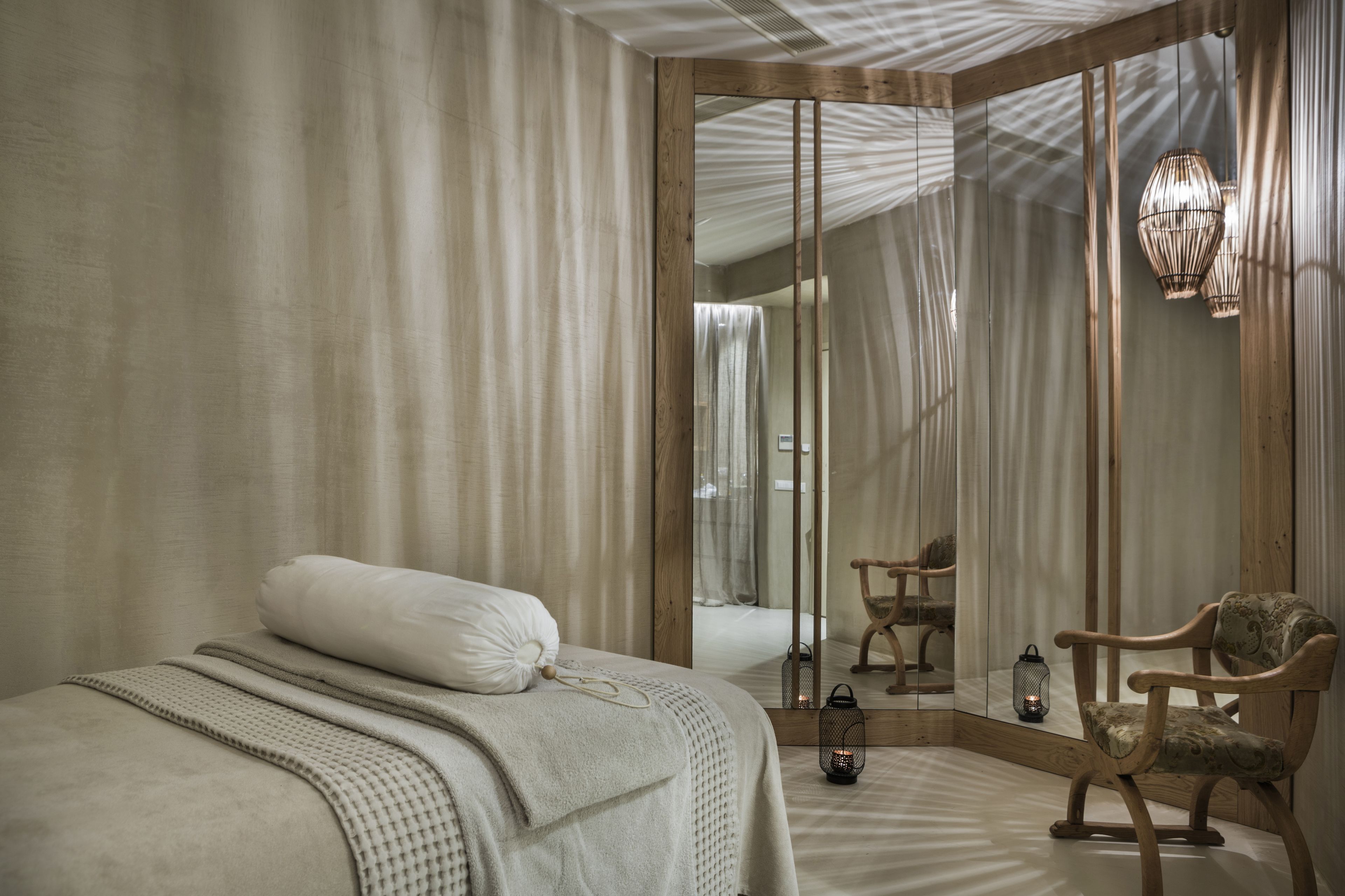 Ein Schlafzimmer mit Bett, Stuhl, Spiegel und einer Laterne.
