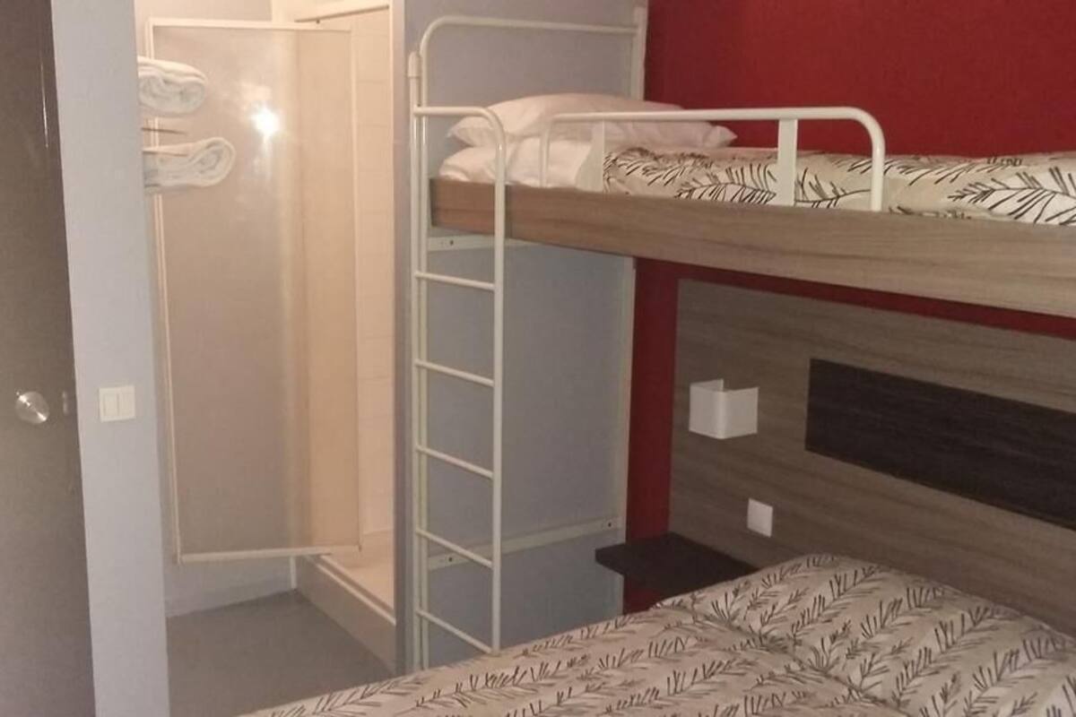 A bunk bed room with a wardrobe and a mirror.