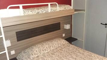 A bunk bed with a patterned mattress and a headboard with a dark panel.