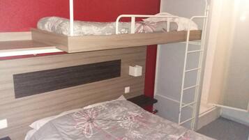 A bunk bed with a wooden frame and a lower bunk with a pillow and a blanket.