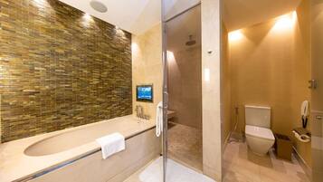 Une salle de bain moderne avec une douche à parois de verre, une baignoire sur pieds et des toilettes.