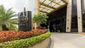 Entrada de un edificio moderno con un letrero que dice 'NUWA Manila'.