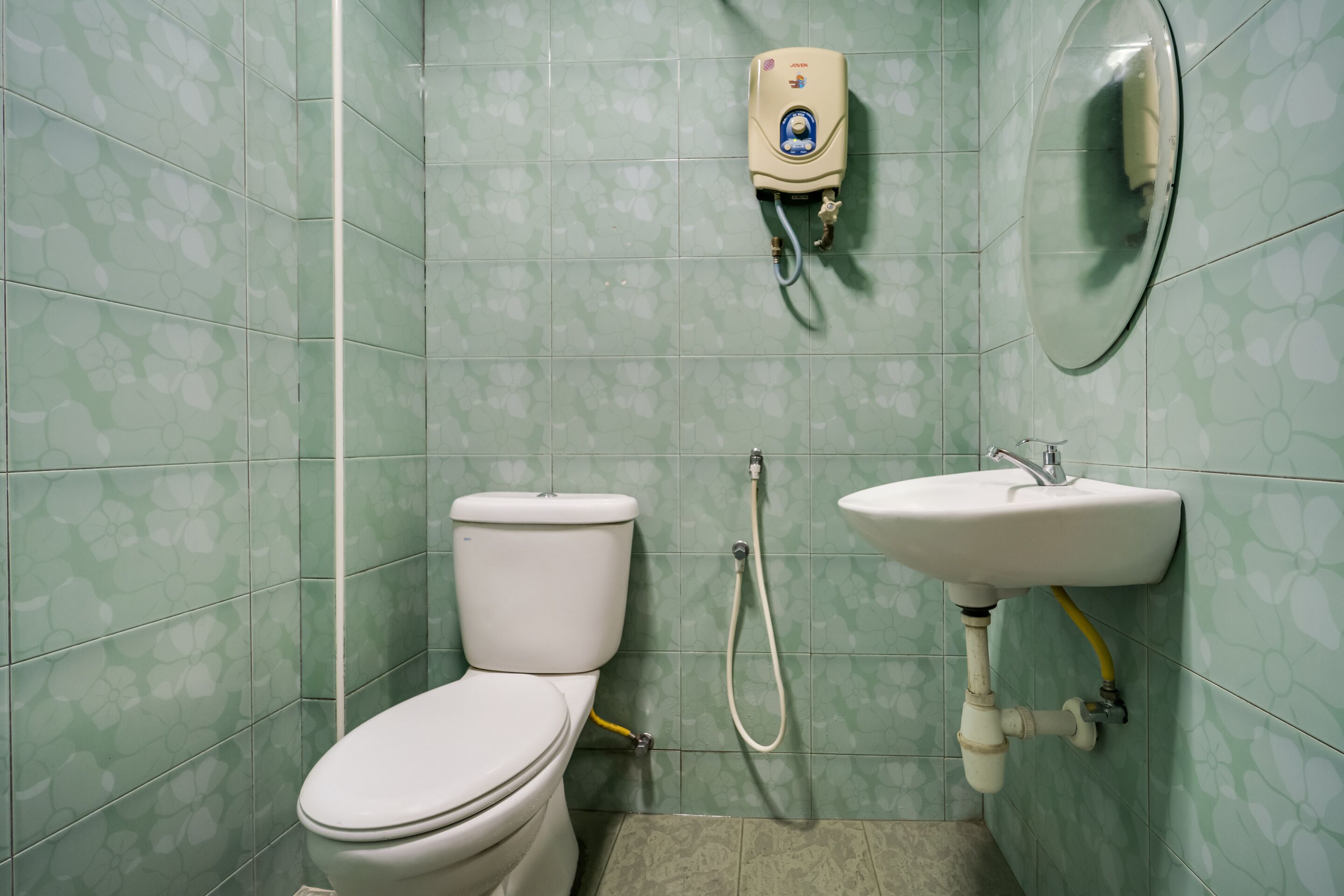 Ein Badezimmer mit Toilette, Handtrockner und Waschbecken.