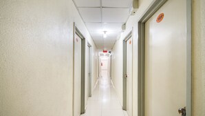 A long, narrow hallway with doors on both sides, each marked with a number. - River Inn Hotel (Butterworth)