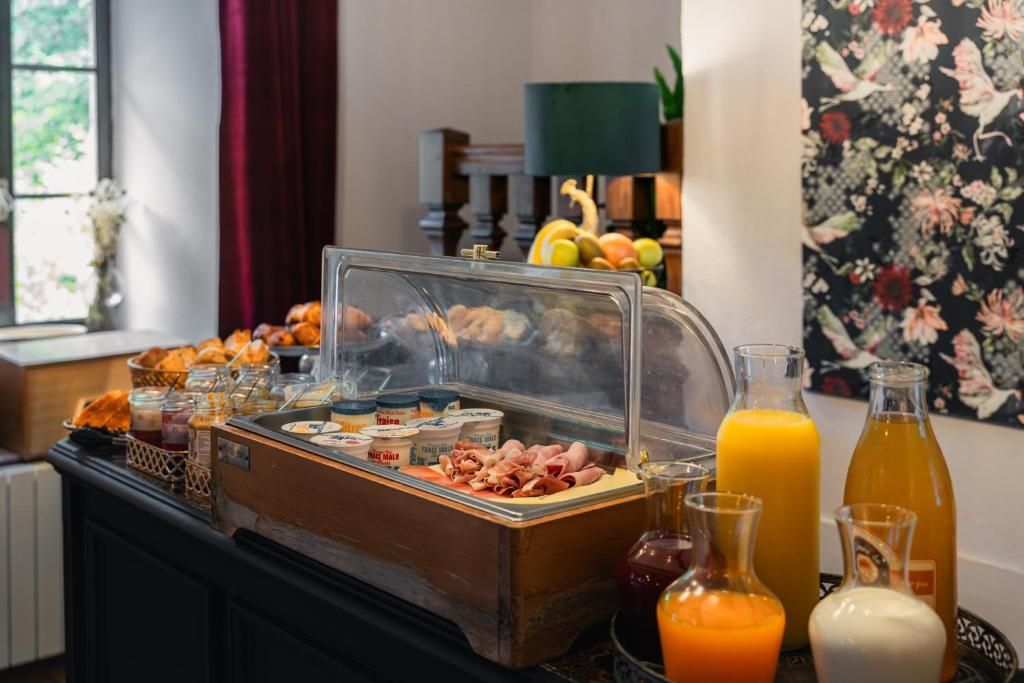 A buffet with various food items, including meats and cheeses, and several bottles of orange juice.