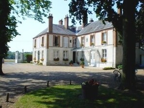 A large, two-story building with a symmetrical facade, multiple windows, and a covered entrance. - Hotel La Villa des Bordes (Clery-Saint-Andre)