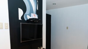 A modern living room with a black entertainment unit, a flat-screen TV, and a minimalist decor. - Davao Royal Suites and Residences (Davao)