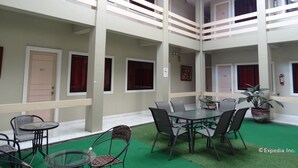 A multi-level atrium with a central table and chairs, surrounded by balconies with railings. - Davao Royal Suites and Residences (Davao)