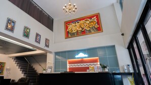 A hotel lobby with a reception desk, a staircase, and a chandelier. - Davao Royal Suites and Residences (Davao)