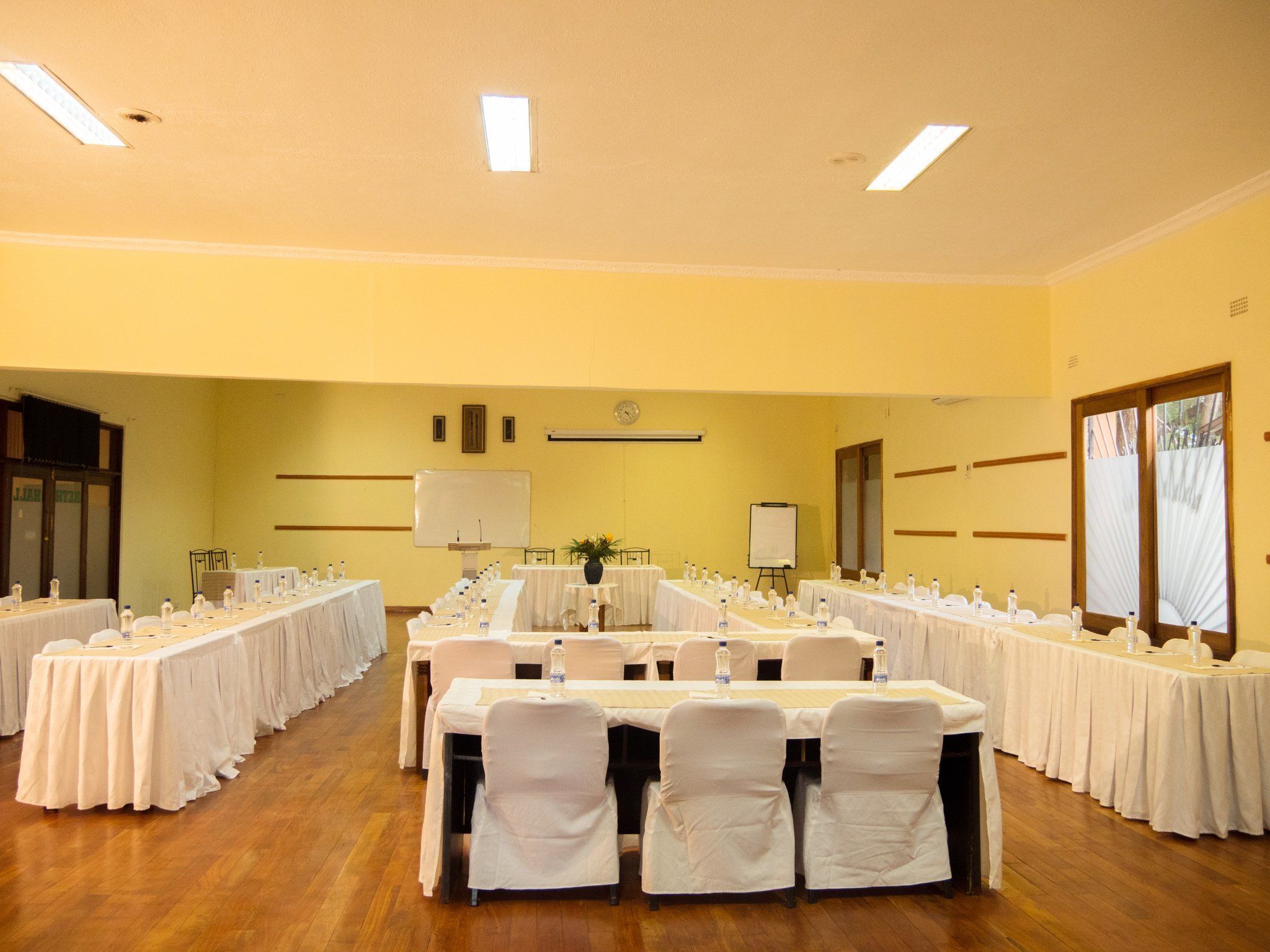 A conference room with multiple tables, chairs, and a whiteboard.